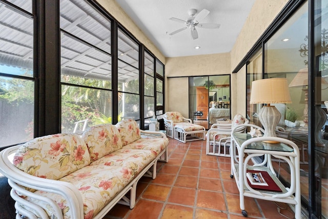 sunroom / solarium featuring ceiling fan, tile patterned floors, and outdoor lounge area