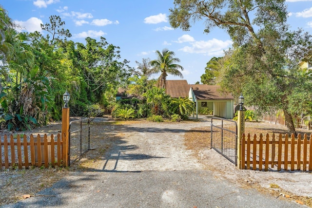 view of street with a gate, a gated entry, and driveway