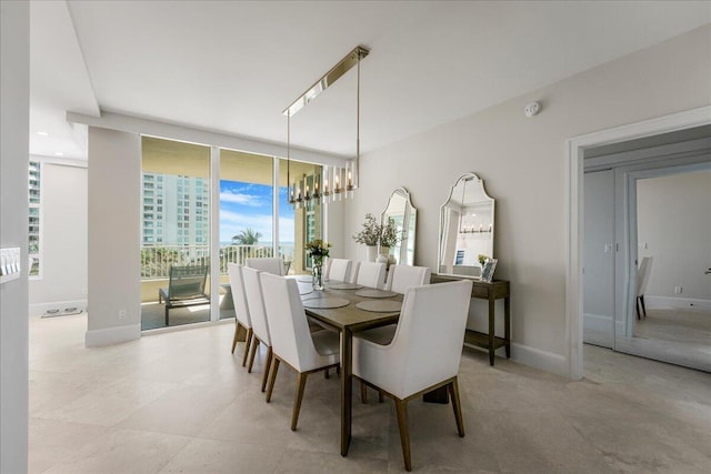 3720 S Ocean Blvd Unit 603, Highland Beach, FL 33487 - dining space with expansive windows, baseboards, and a notable chandelier