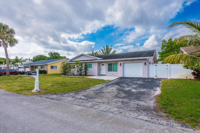 3338 NW 69th St, Fort Lauderdale, FL 33309 - single story home with aphalt driveway, a gate, stucco siding, an attached garage, and a front yard