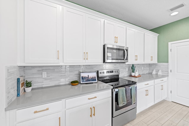 8781 Corvus Dr, Lake Worth, FL 33467 - kitchen with white cabinets, light countertops, visible vents, and appliances with stainless steel finishes