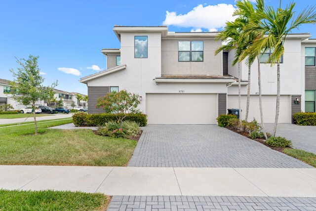 8781 Corvus Dr, Lake Worth, FL 33467 - view of front of house with decorative driveway, a garage, a front yard, stucco siding, and a residential view