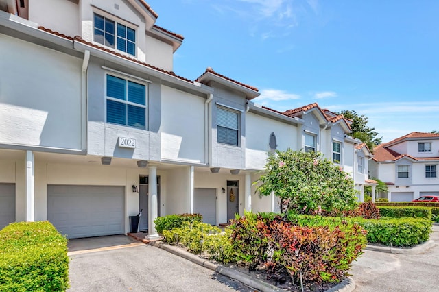 2022 Alta Meadows Ln Unit 605, Delray Beach, FL 33444 - townhome / multi-family property with a garage, stucco siding, a tile roof, a residential view, and driveway