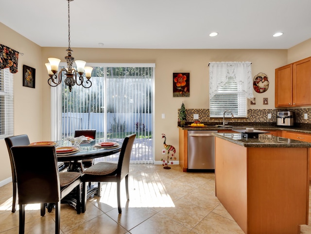 kitchen with a notable chandelier, decorative backsplash, light tile patterned floors, stainless steel dishwasher, and pendant lighting