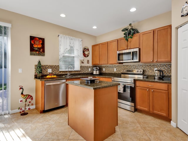kitchen featuring backsplash, appliances with stainless steel finishes, a center island, a sink, and recessed lighting