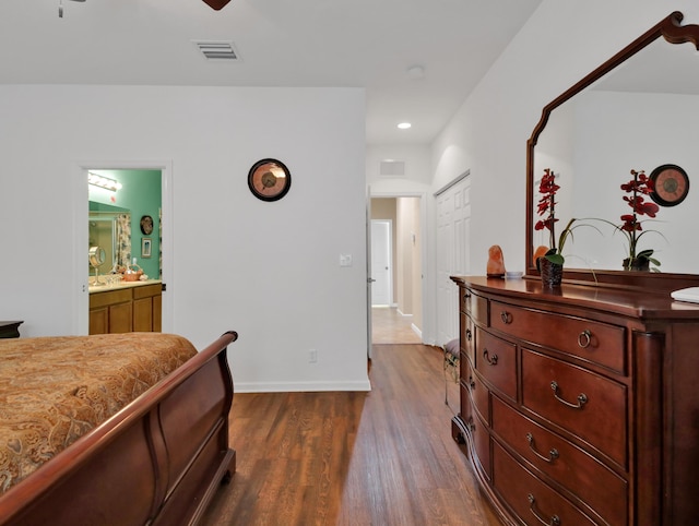bedroom with baseboards, dark wood finished floors, ensuite bathroom, and visible vents