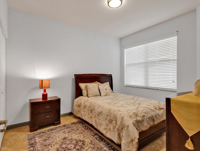 bedroom with baseboards and light tile patterned floors