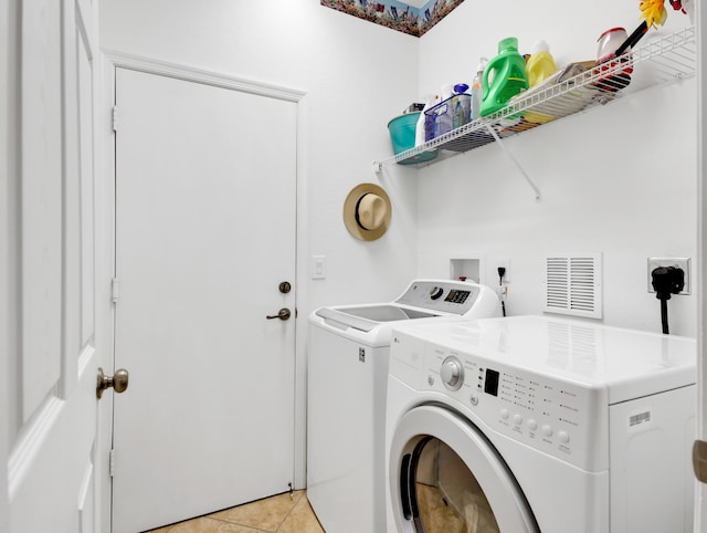 laundry area featuring laundry area, light tile patterned floors, washer and dryer, and visible vents