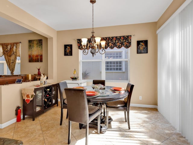 dining area featuring baseboards and a notable chandelier