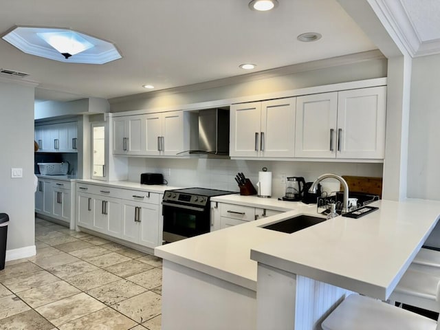 kitchen with wall chimney exhaust hood, electric stove, a sink, ornamental molding, and a peninsula