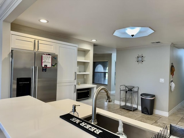 kitchen with stainless steel fridge, ornamental molding, white cabinetry, open shelves, and baseboards