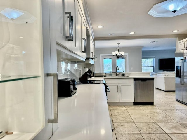 kitchen featuring stainless steel appliances, crown molding, a sink, a peninsula, and open floor plan
