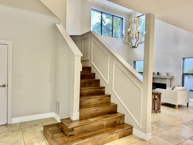 stairs featuring a chandelier and baseboards