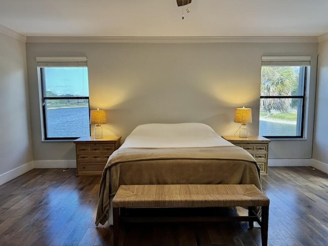 bedroom with wood-type flooring, crown molding, and baseboards