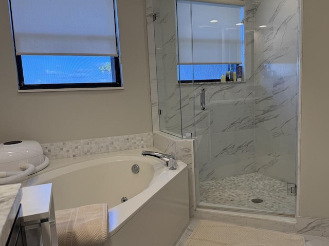bathroom featuring a bath, a shower stall, vanity, and marble finish floors