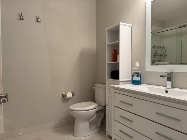 bathroom with toilet, an enclosed shower, vanity, tile patterned flooring, and baseboards