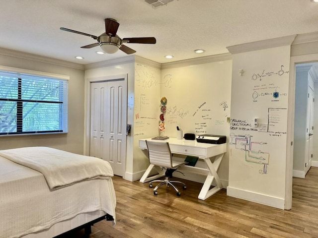 bedroom with crown molding, wood finished floors, baseboards, a closet, and ceiling fan
