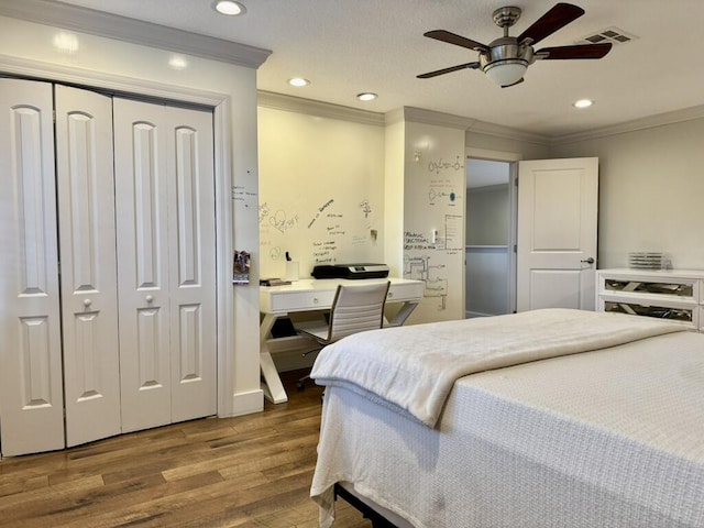 bedroom featuring wood finished floors, crown molding, recessed lighting, a closet, and a desk