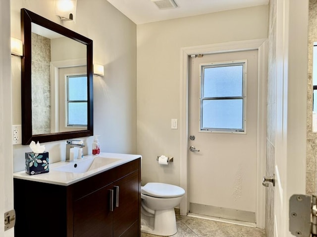 bathroom featuring toilet, vanity, and tile patterned flooring