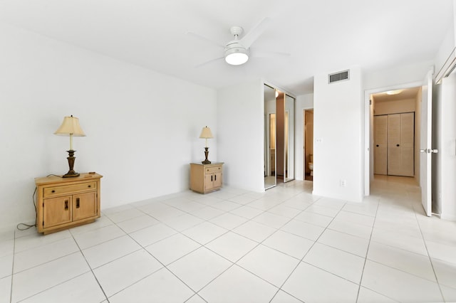 empty room featuring visible vents, ceiling fan, and light tile patterned floors