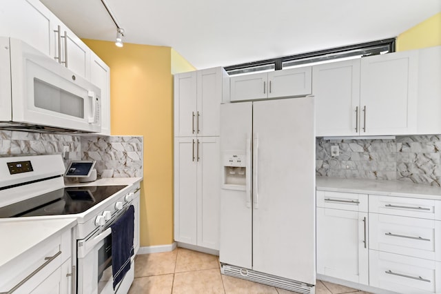 kitchen featuring white cabinets, light countertops, light tile patterned floors, white appliances, and decorative backsplash