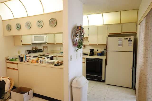 3302 SE Guinevere Ln, Port Saint Lucie, FL 34952 - kitchen with cream cabinets, light tile patterned flooring, white appliances, and light countertops