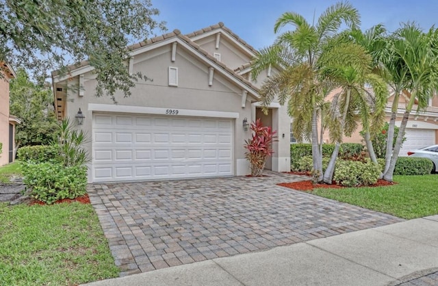 5959 SE Crooked Oak Ave, Hobe Sound, FL 33455 - view of front of property featuring stucco siding, a tiled roof, a garage, and decorative driveway