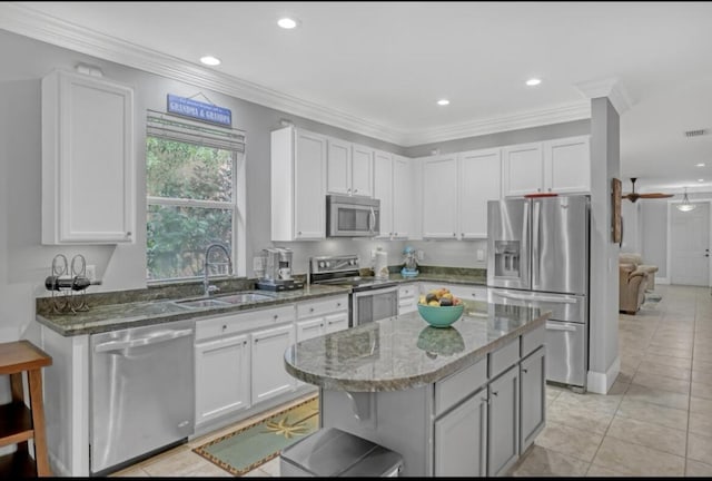 5959 SE Crooked Oak Ave, Hobe Sound, FL 33455 - kitchen with stainless steel appliances, a center island, a sink, dark stone counters, and light tile patterned floors
