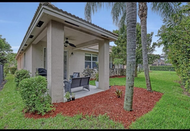 5959 SE Crooked Oak Ave, Hobe Sound, FL 33455 - exterior space with fence, a patio area, ceiling fan, a yard, and stucco siding