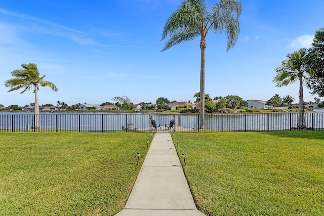 view of yard featuring a water view, fence, and a residential view