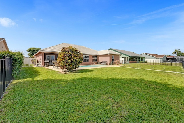 rear view of house with a yard, a fenced backyard, and a patio area