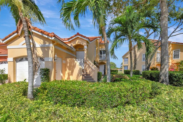 17051 Emile St Unit 5, Boca Raton, FL 33487 - view of front of property featuring stucco siding, an attached garage, and a tile roof
