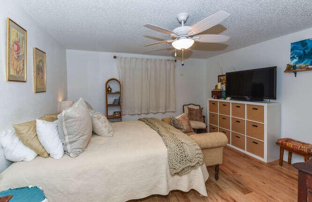 bedroom featuring a ceiling fan, wood finished floors, and a textured ceiling