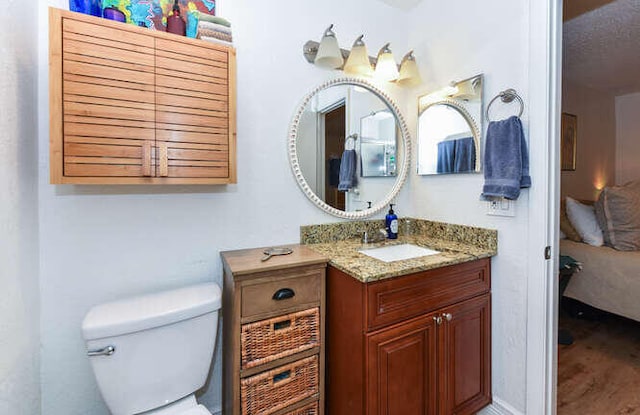 bathroom featuring ensuite bath, vanity, and toilet