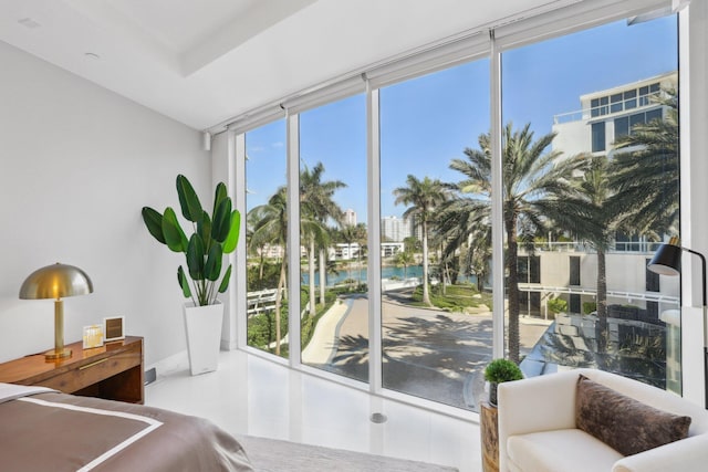 bedroom featuring a water view and multiple windows