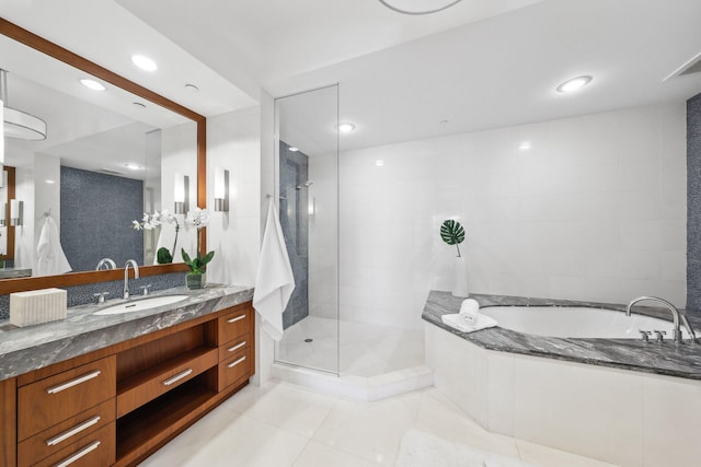 bathroom featuring vanity, a bath, tile patterned flooring, and a stall shower