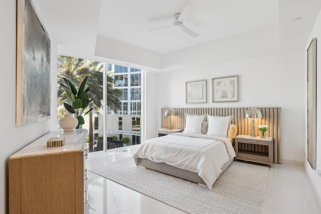 bedroom with expansive windows, light tile patterned floors, and a ceiling fan