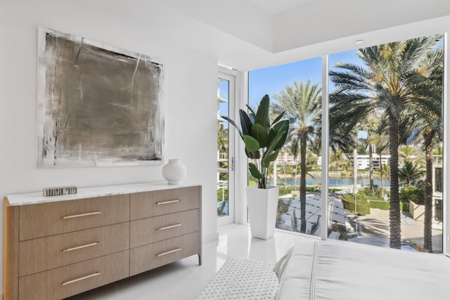 bedroom featuring light tile patterned floors, expansive windows, and a water view
