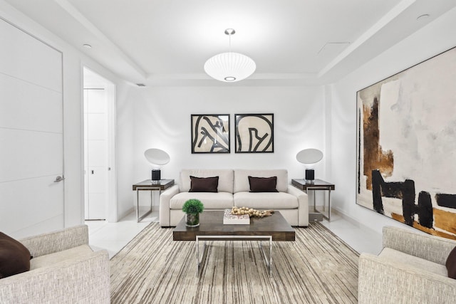 living area featuring tile patterned flooring and a raised ceiling