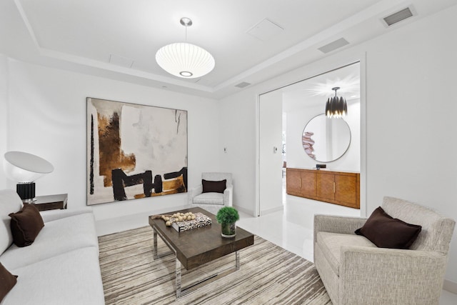 living area featuring visible vents and a raised ceiling