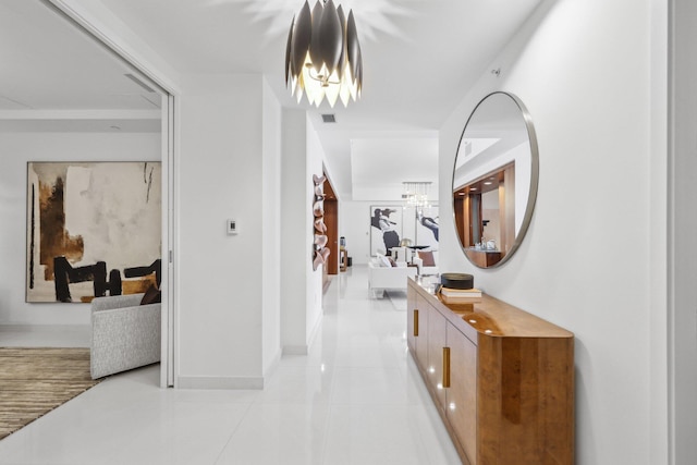corridor with baseboards, a chandelier, visible vents, and light tile patterned floors