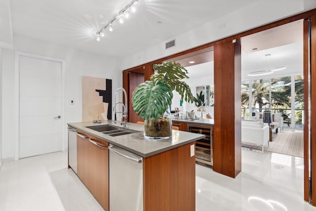 kitchen featuring beverage cooler, visible vents, modern cabinets, a sink, and a kitchen island with sink