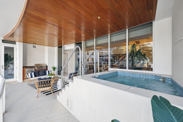 pool with a grill, exterior kitchen, and an outdoor hangout area