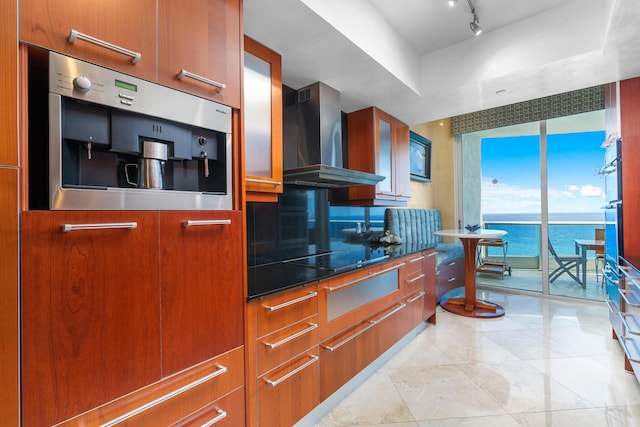1600 S Ocean Blvd Unit Mph02, Lauderdale By The Sea, FL 33062 - kitchen featuring wall chimney range hood, brown cabinetry, modern cabinets, and a water view