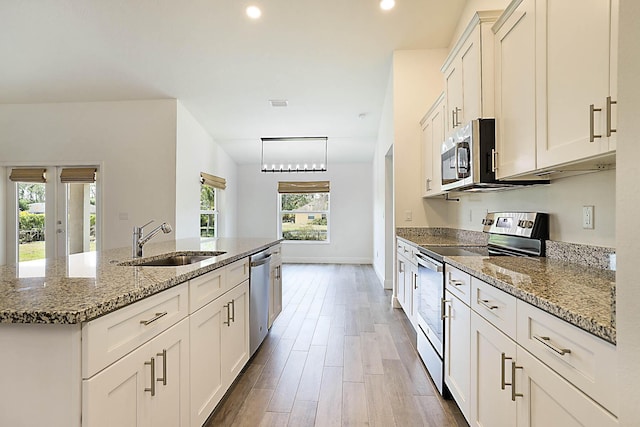 17854 N 71st Ln N, The Acreage, FL 33470 - kitchen with stainless steel appliances, a sink, a center island with sink, stone countertops, and recessed lighting