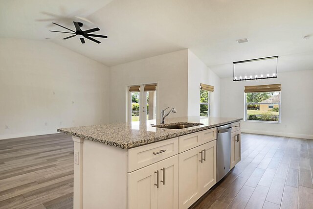 17854 N 71st Ln N, The Acreage, FL 33470 - kitchen featuring a sink, dishwasher, light wood-style flooring, light stone countertops, and a center island with sink