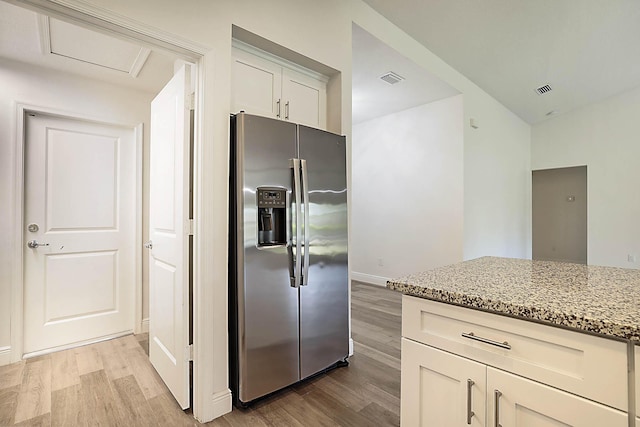 17854 N 71st Ln N, The Acreage, FL 33470 - kitchen featuring stainless steel refrigerator with ice dispenser, light wood-style flooring, light stone countertops, and baseboards