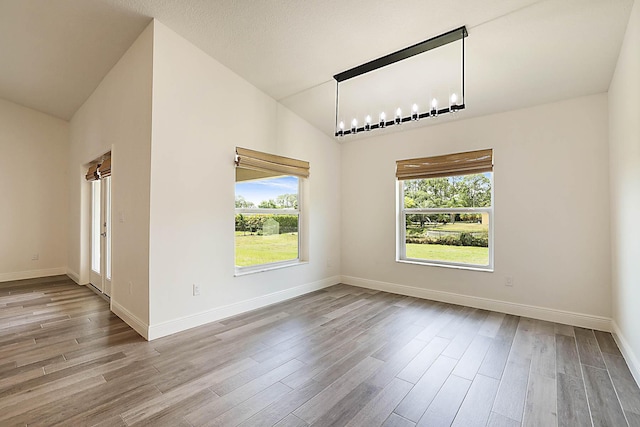 17854 N 71st Ln N, The Acreage, FL 33470 - unfurnished dining area with wood finished floors, lofted ceiling, and baseboards