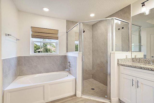 17854 N 71st Ln N, The Acreage, FL 33470 - bathroom with a shower stall, a bath, vanity, wood finished floors, and recessed lighting