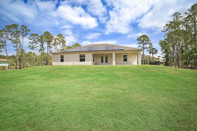 17854 N 71st Ln N, The Acreage, FL 33470 - back of property with solar panels, a lawn, french doors, stucco siding, and a patio